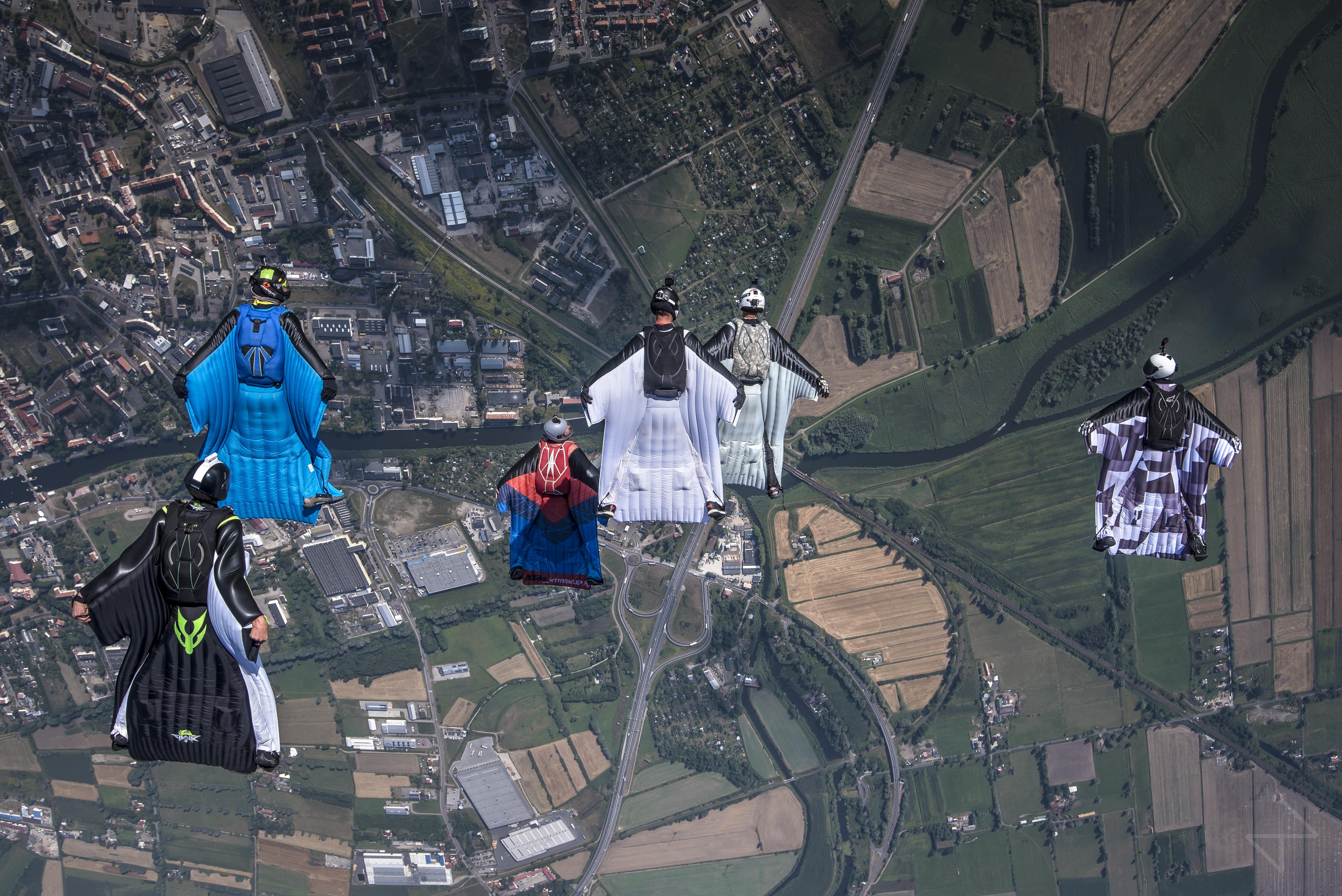 Skoczkowie w strojach wingsuit nad ziemią. // fot. mat. prasowe